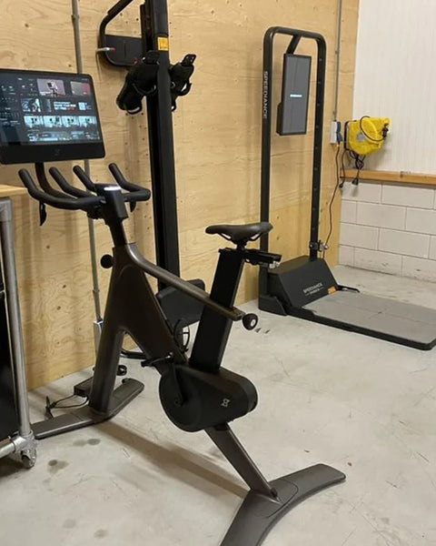 Een Gym Monster in een garageruimte naast een hometrainer