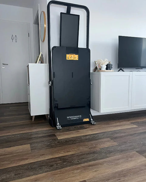 Een Gym Monster rechtop opgeklapt in een woonkamer naast een tv-meubel