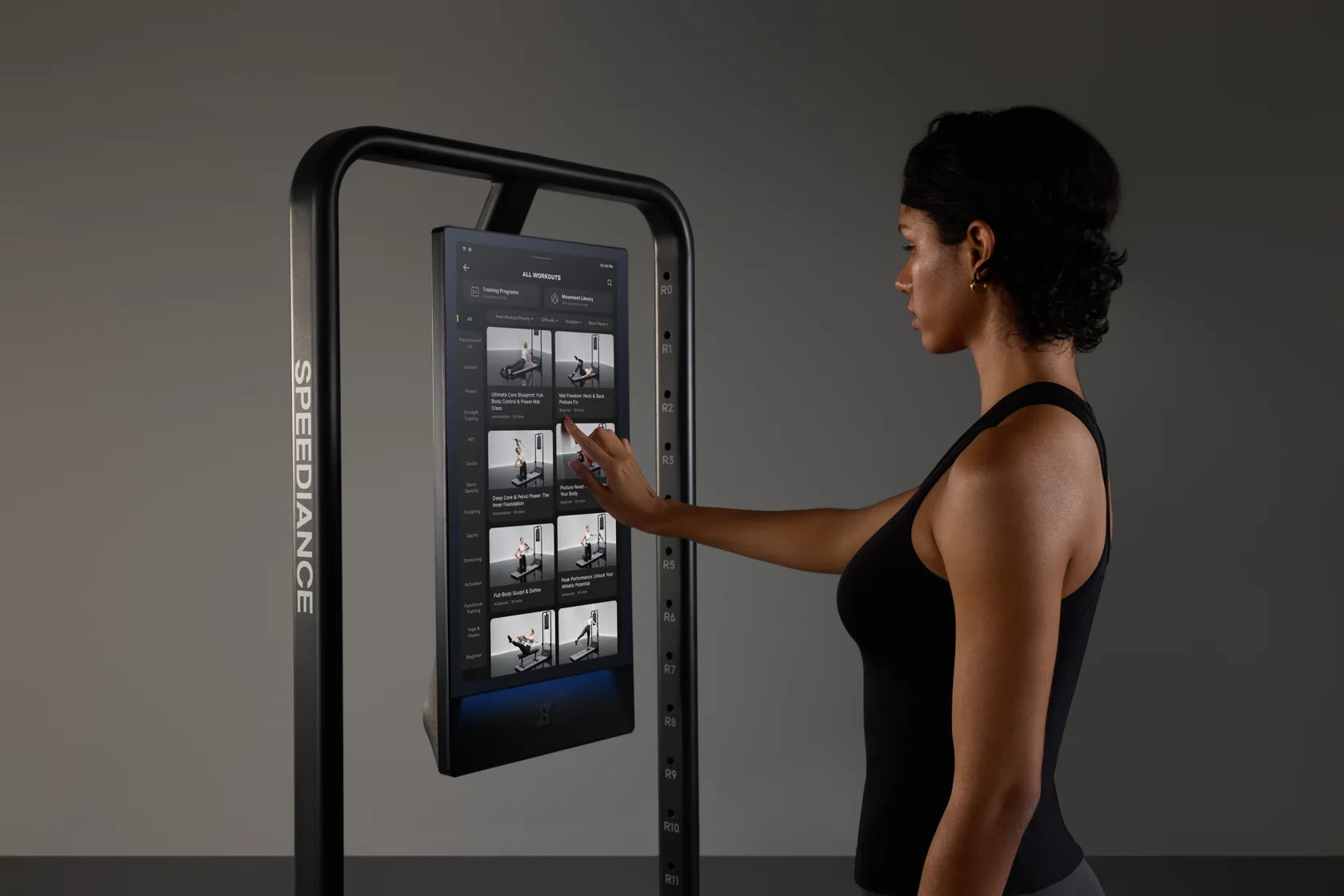 Une femme choisissant un entraînement sur le vrai écran tactile de Gym Monster 3