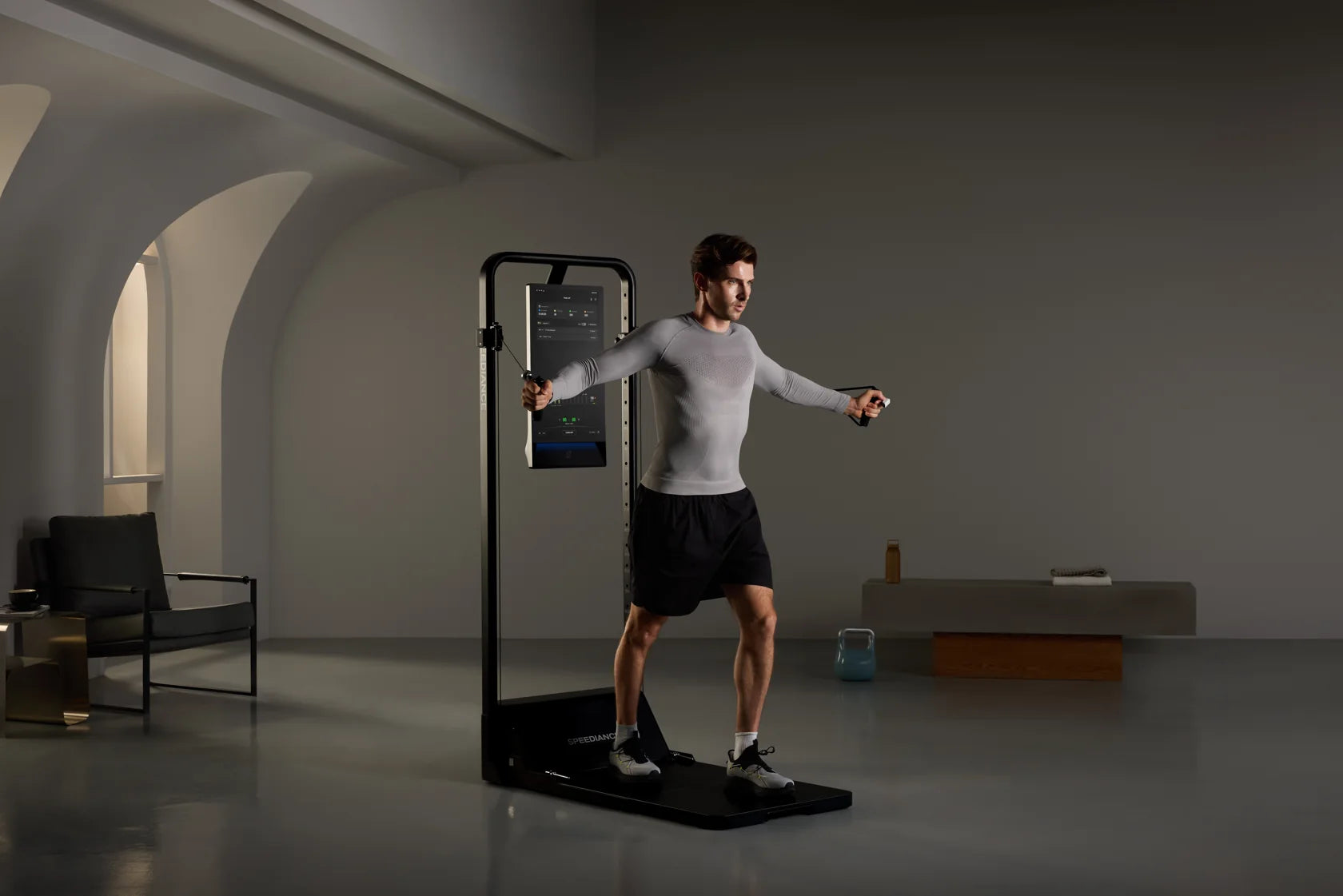 Een man traint op Gym Monster 3 in een rustige, zacht verlichte kamer